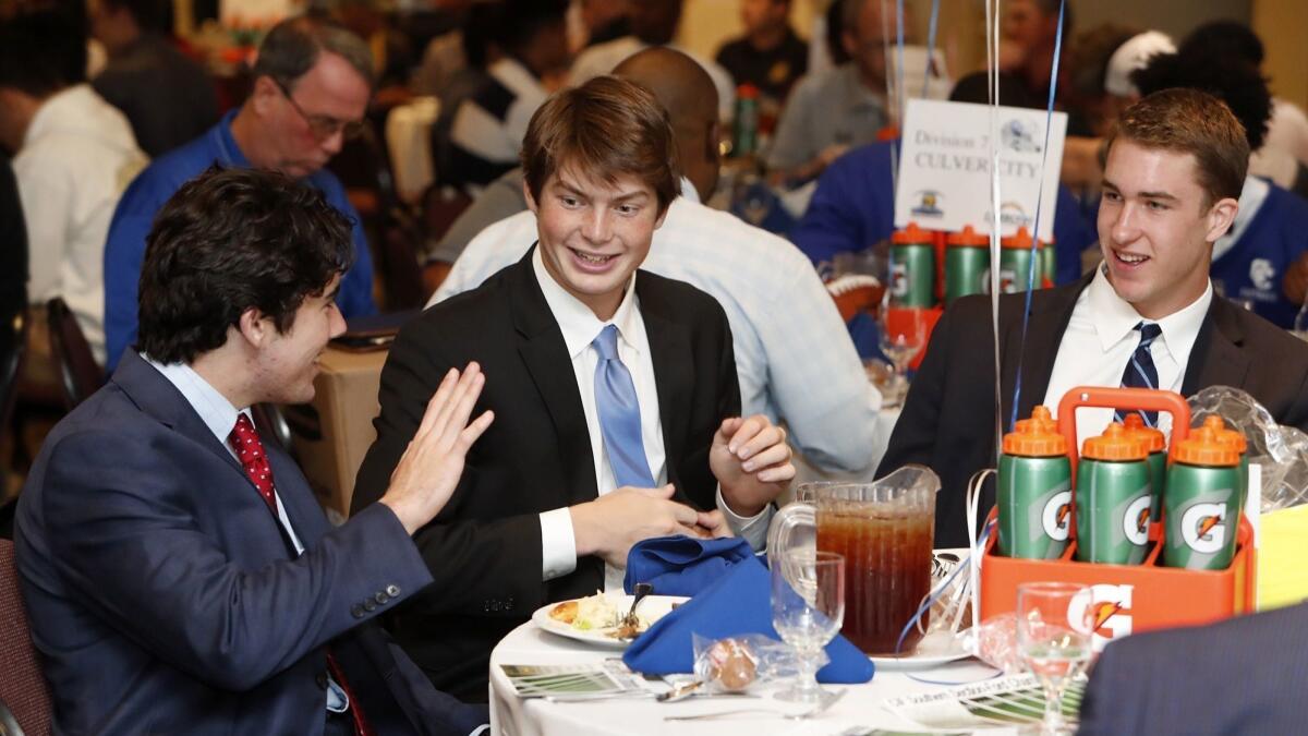 Corona del Mar High linebacker Luke Fisher, left, quarterback Ethan Garbers, center, and wide receiver John Humphreys, right, attend the CIF Southern Section football championship luncheon at the Grand Long Beach on Monday.
