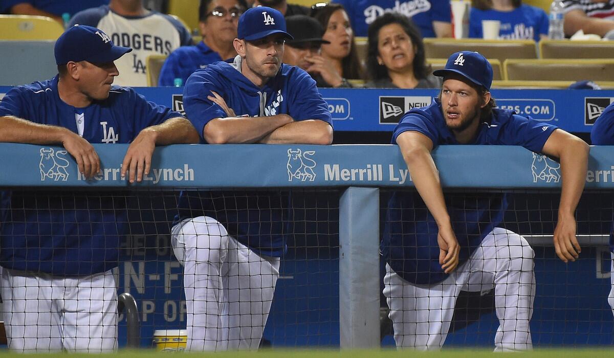Dodgers ace Clayton Kershaw, right, chatting with catcher A.J. Ellis, left, and pitcher Brandon McCarthy, might not pitch again this season.
