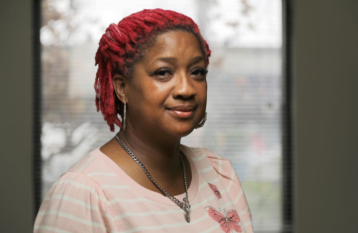 A woman in red hair smiles.