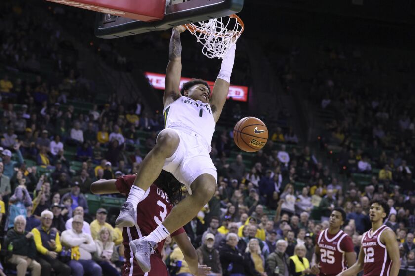 Baylor guard Keyonte George (1) dunks over Oklahoma guard Otega Oweh (3) during the first half of an NCAA college basketball game Wednesday, Feb. 8, 2023, in Waco, Texas. (AP Photo/Rod Aydelotte)