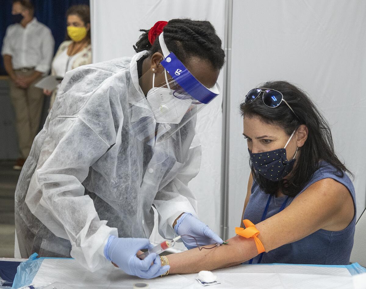 Rita Moisson draws blood from Robin Gaven at the Las Virgenes Unified School District headquarters in Calabasas.