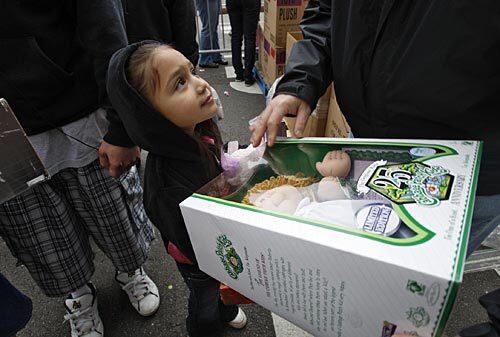 Alondra Samorano, 5, gets a doll on Christmas Eve, when a Christmas meal and toys for children were provided at the Los Angeles Mission downtown.