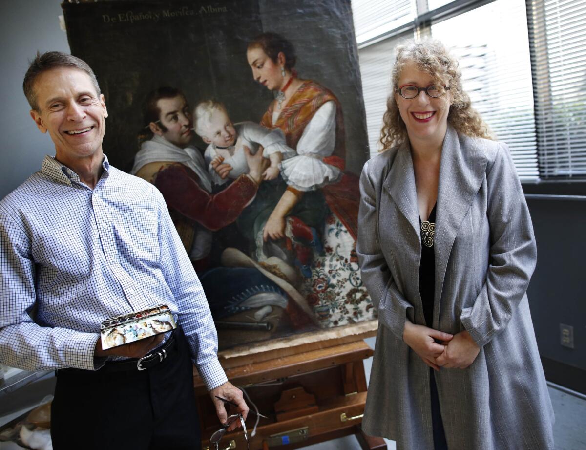 Joseph Fronek, left, a LACMA paintings conservator, and Latin American art curator Ilona Katzew discuss the rare 18th century casta painting by Miguel Cabrera that was found under a couch. The museum has acquired the work.