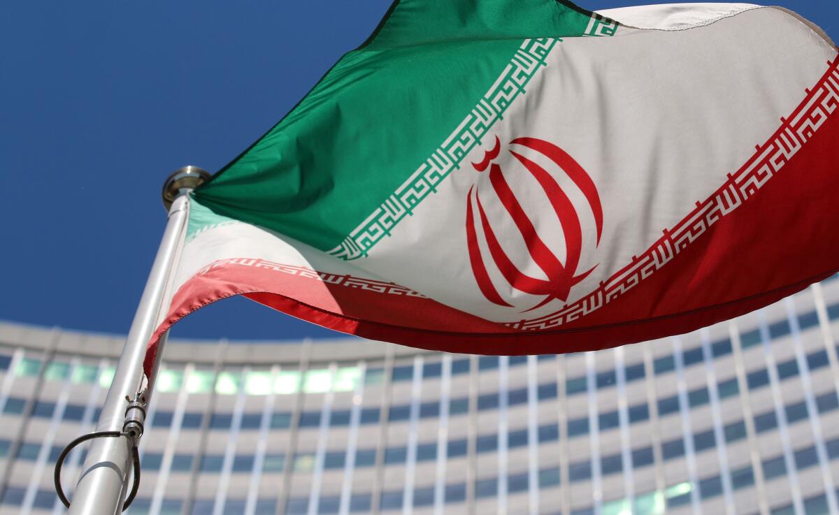 The Iranian flag flies in front of a U.N. building where closed-door nuclear talks take place at the International Center in Vienna.