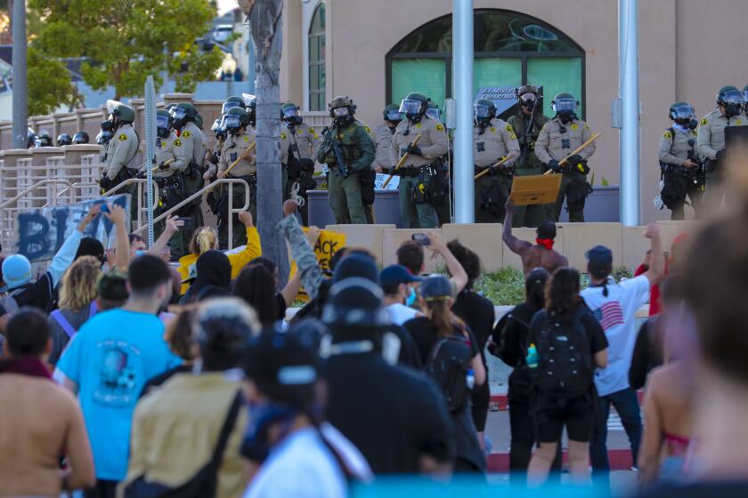 Sheriff deputies take up positions at an entrance to the La Mesa Police Department where more than a thousand protestors held a demonstration on Saturday.