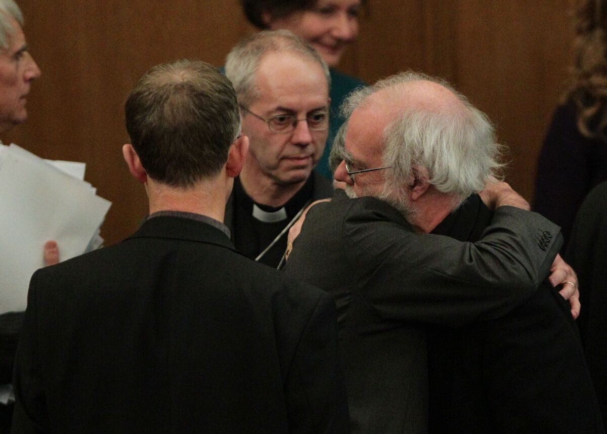 Rowan Williams, the outgoing archbishop of Canterbury, is hugged by a colleague after draft legislation to allow female bishops in the Church of England failed to receive final approval.
