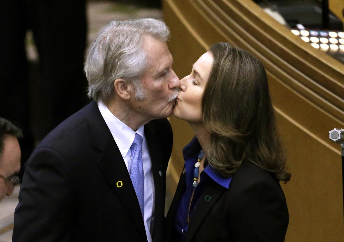 Oregon Gov. John Kitzhaber kisses his fiancee, Cylvia Hayes, in January after he was sworn in for an unprecedented fourth term.