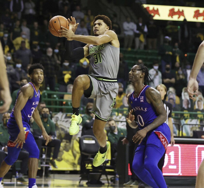 File-Baylor guard MaCio Teague, front left, scores past Kansas guard Marcus Garrett in the second half of an NCAA college basketball game, Monday, Jan. 18, 2021, in Waco, Texas. Teague and Davion Mitchell, two of the league’s best shooters, were part of a Big 12-record 23-game winning streak last season in their debuts as Baylor starters. Those former transfers had also gone through a redshirt season together. (Rod Aydelotte/Waco Tribune-Herald via AP, File)