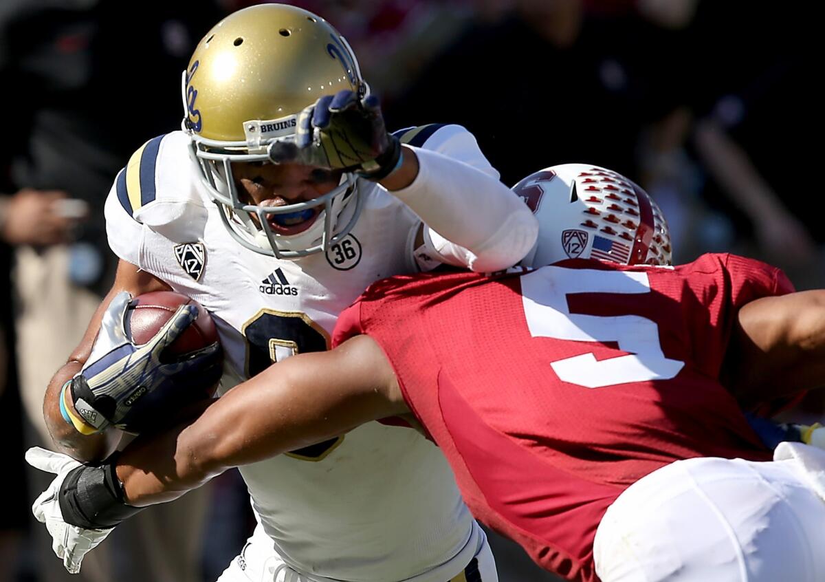 UCLA wide receiver Jordan Payton, left, fights for yards against Stanford cornerback Devon Carrington during the Bruins' loss Saturday. UCLA will look to upset Oregon this week.