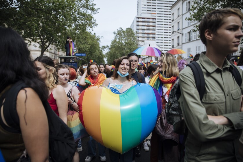 En esta imagen de archivo, una participante sostiene un corazón con la bandera arcoiris 