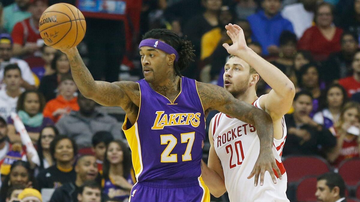 Lakers forward Jordan Hill, left, looks to pass while being guarded by Houston Rockets forward Donatas Motiejunas during the first half of Wednesday's game.