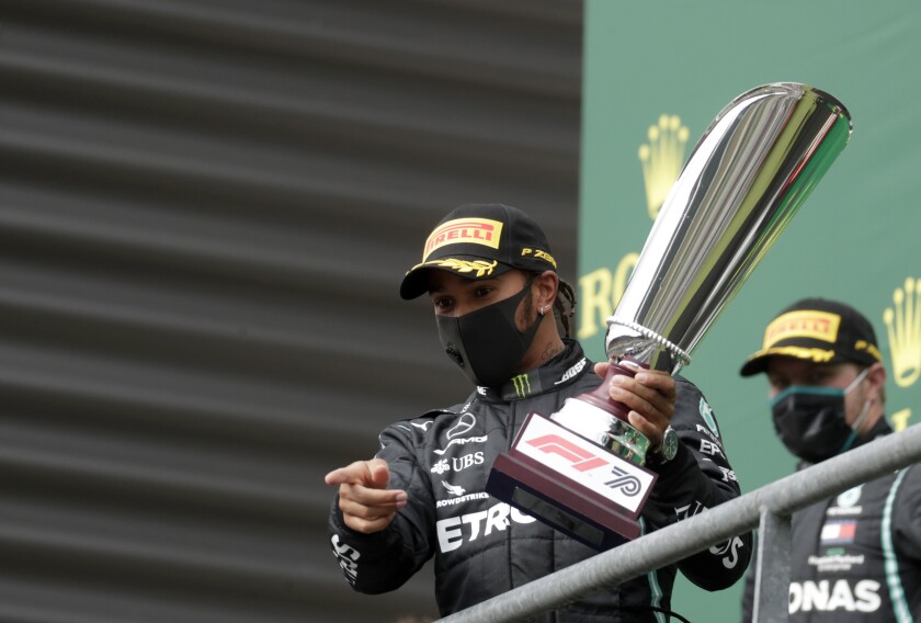 Lewis Hamilton celebrates on the podium after winning the Formula One Grand Prix at the Spa-Francorchamps racetrack.