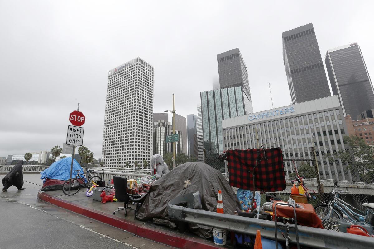 Children's toys, recyclables and old furniture line the sidewalk at a homeless encampment beside the Harbor Freeway in downtown Los Angeles on Wednesday.
