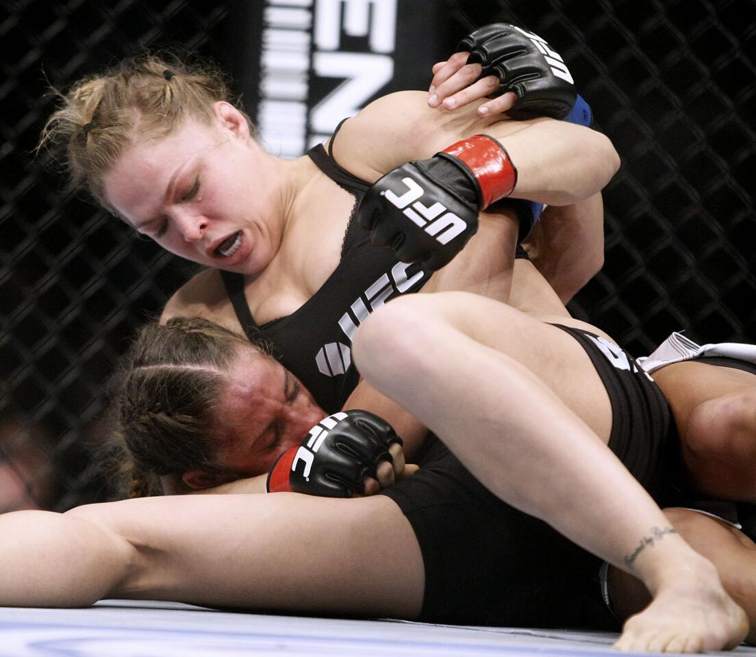 Ronda Rousey, top, punishes ex-Marine Liz Carmouche in the first round of the UFC157 to win by a tap out at the Honda Center in Anaheim on Saturday, February 23, 2013. Ronda Rousey, who trains at the Glendale Fighting Club in Glendale, defended her world championship title in the main event.