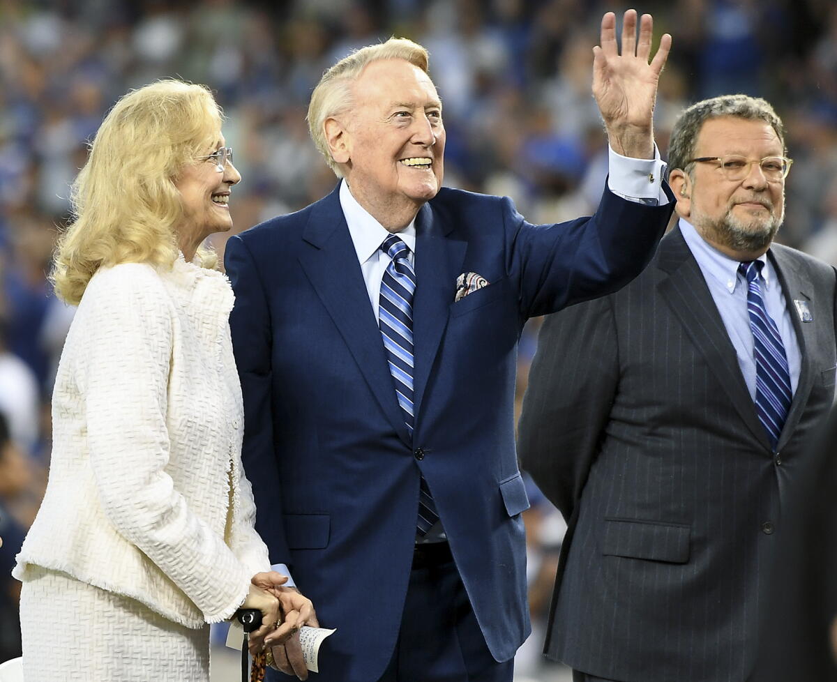 Dodgers spikeri Vin Scully (ortada), Charley Steiner (sağda) 20 Eylül 2016'daki maç öncesinde seyircilere el sallıyor.