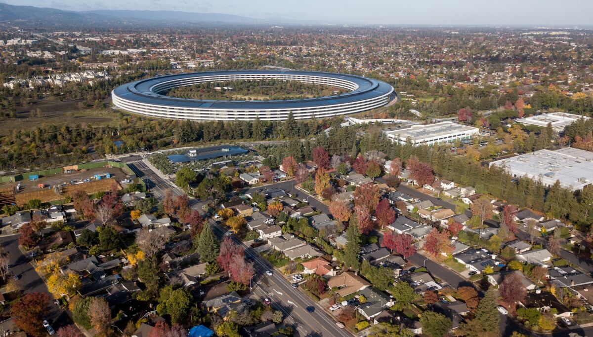 The futuristic Apple headquarters is set against suburban housing in Cupertino.