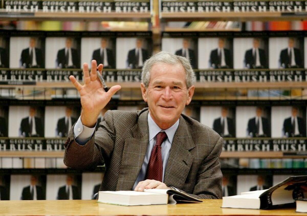 Former U.S. President George W. Bush waves while signing copies of his new memoir "Decision Points" at Borders Books on November 9, 2010 in Dallas, Texas.