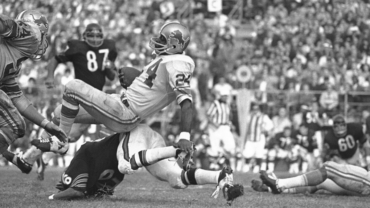 Detroit Lions running back Mel Farr (24) balances atop Chicago Bears back Bennie McRae (26) after snaring a 16-yard pass from quarterback Bill Munson in a game on Oct. 26, 1970, in Chicago.