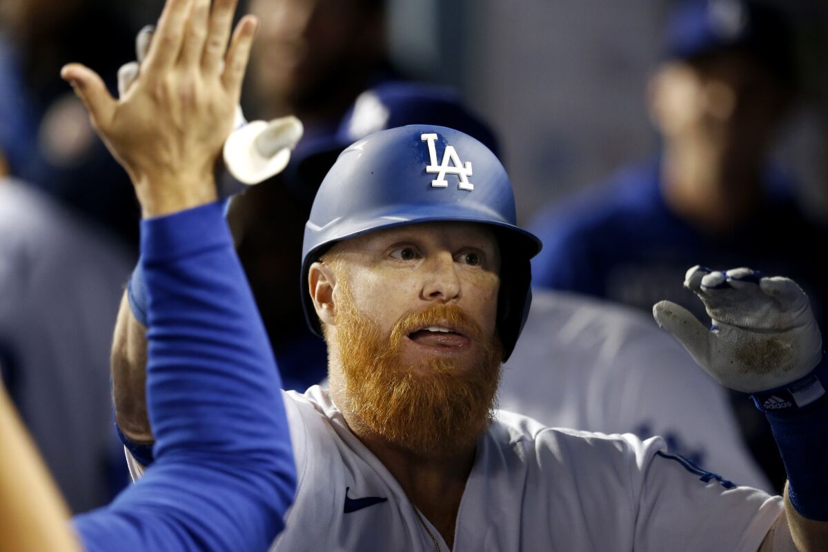 Dodgers third baseman Justin Turner celebrates with teammates in the dugout.