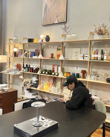A man sips coffee in a lifestyle store and coffee house.