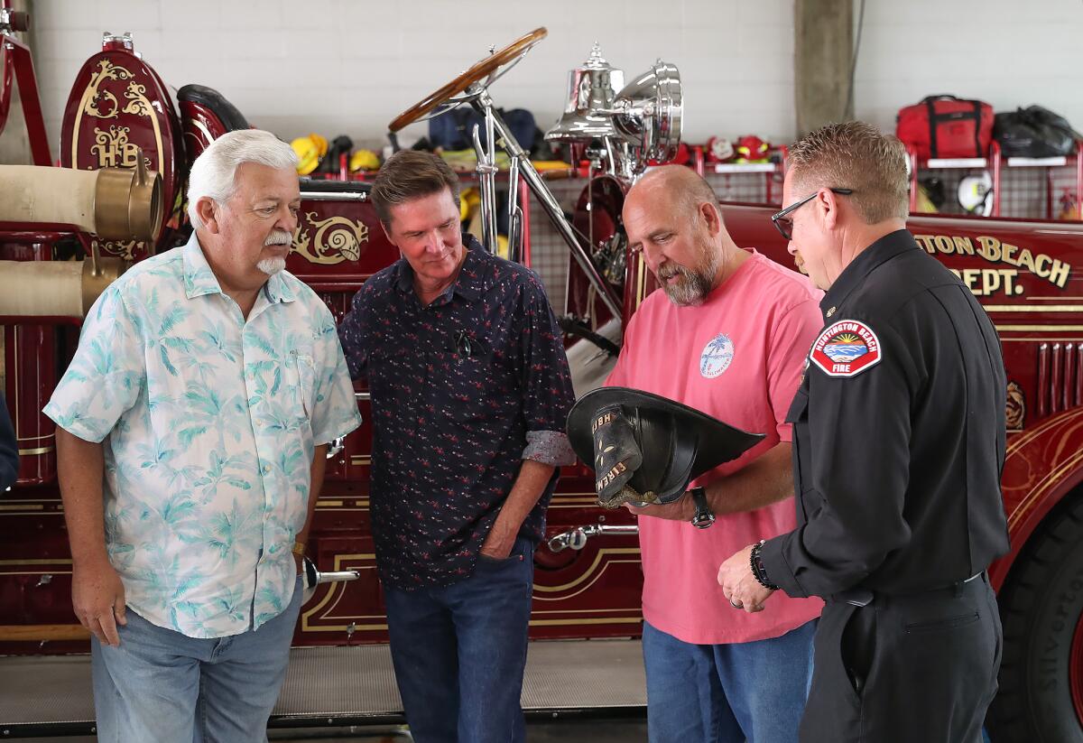 Terry Hibler, Dave Hibler, Mayor Pro Tem Pat Burns and Fire Chief Scott Haberle check out the donated helmet. 