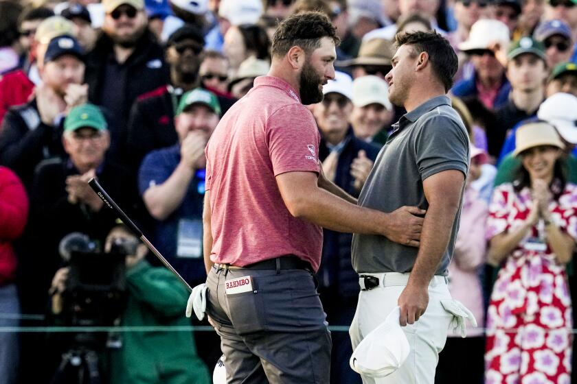 Jon Rahm, of Spain, embraces Brooks Koepka on the 18th hole after winning the 2023 Masters