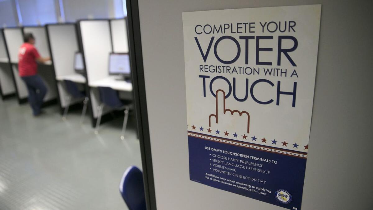 A sign advertises a touch-screen voter registration process at the Department of Motor Vehicles in Santa Ana.