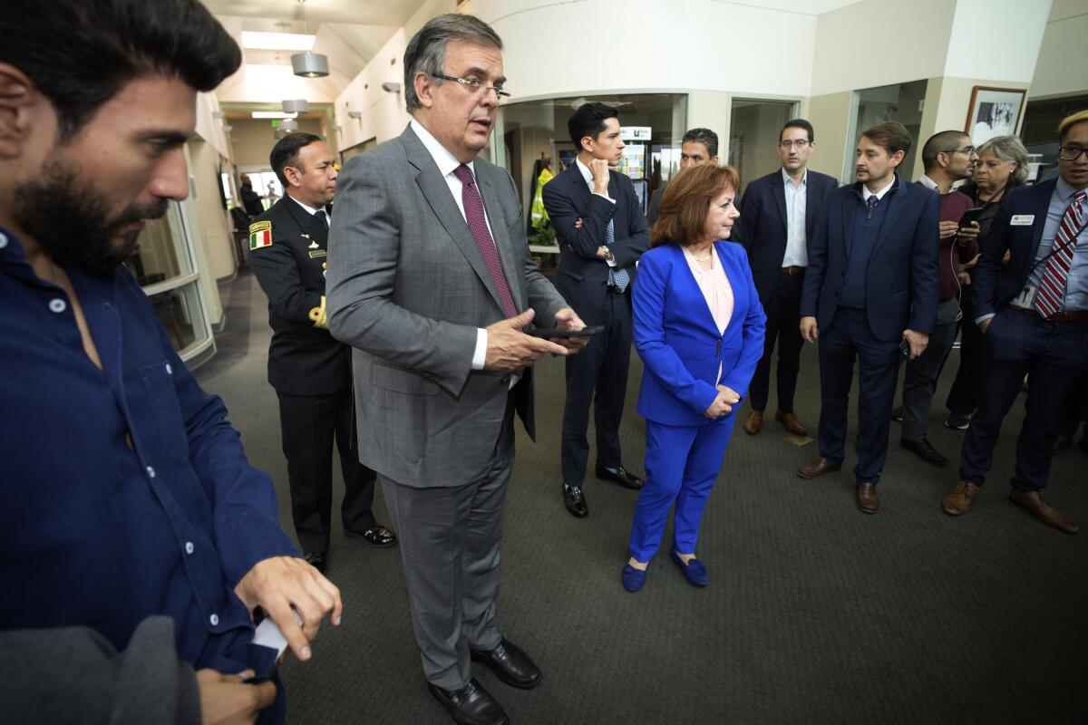 Marcelo Ebrard, center left, stands with a group of people.