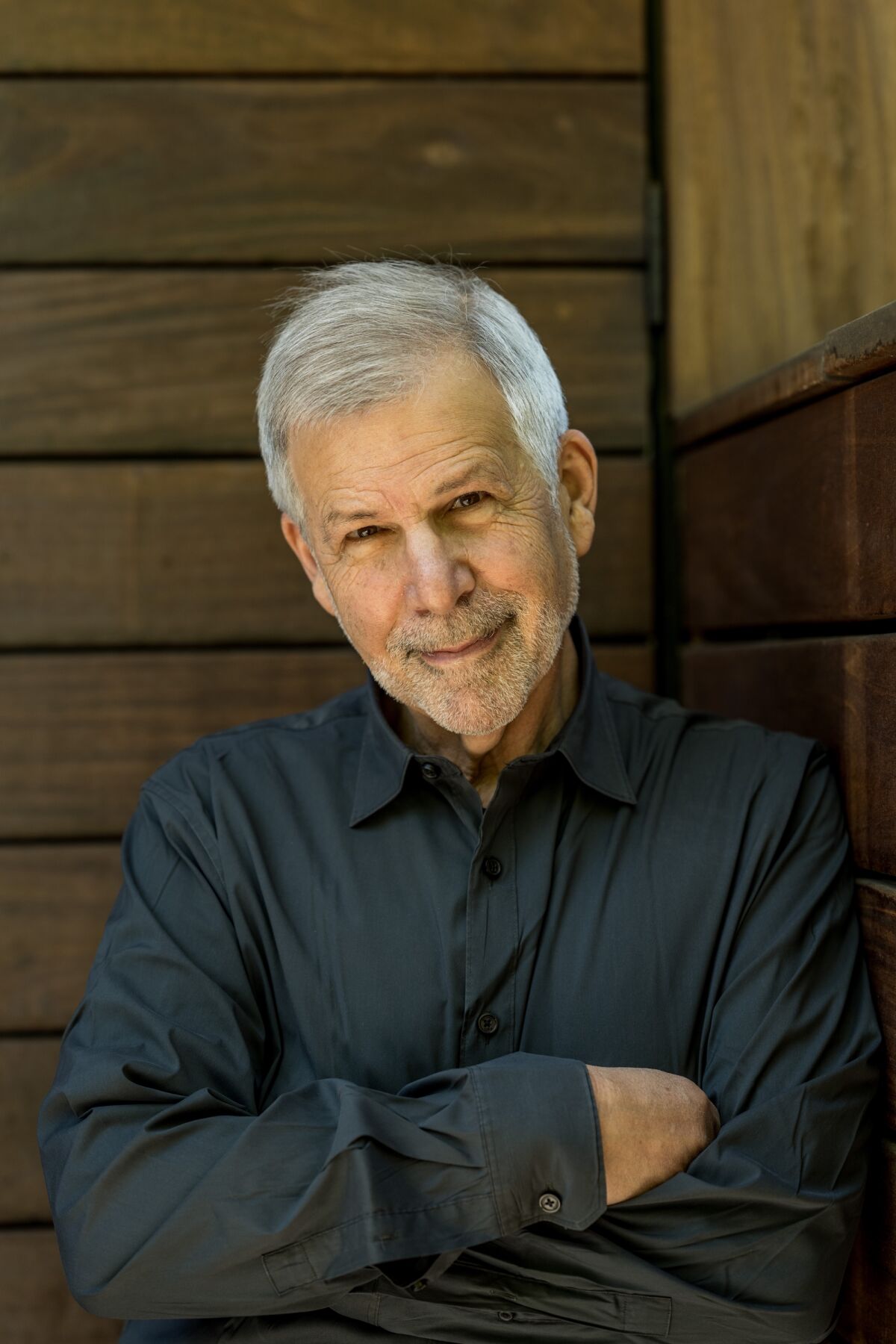 A headshot of a man in a dark gray button-down 