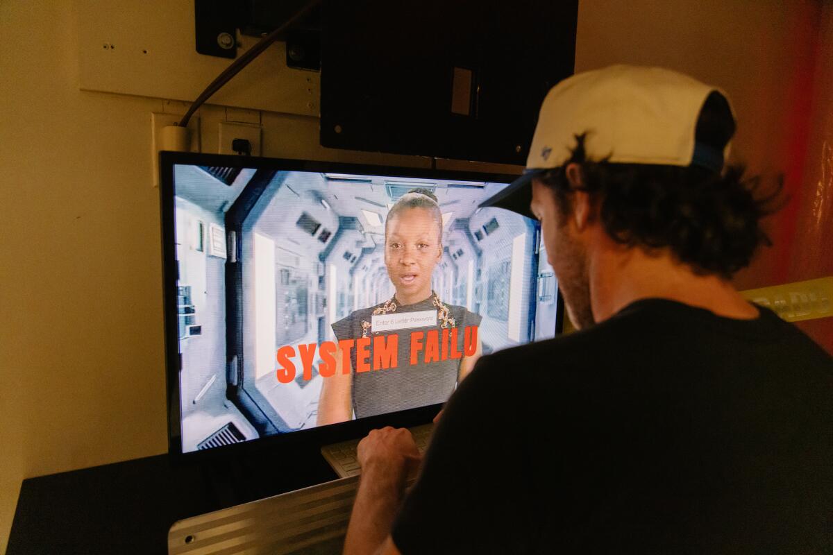 A guest in a ball ball interacts with a screen.