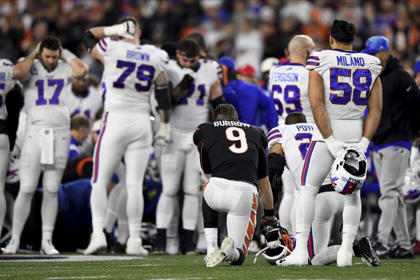 Cincinnati Bengals quarterback Joe Burrow (9) pauses as Buffalo Bills' Damar Hamlin is examined by medical staff