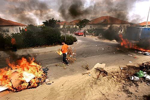 Residents of Neve Dekallim set trash fires on many street corners to prevent the arrival of buses that will be used to remove the settlers.