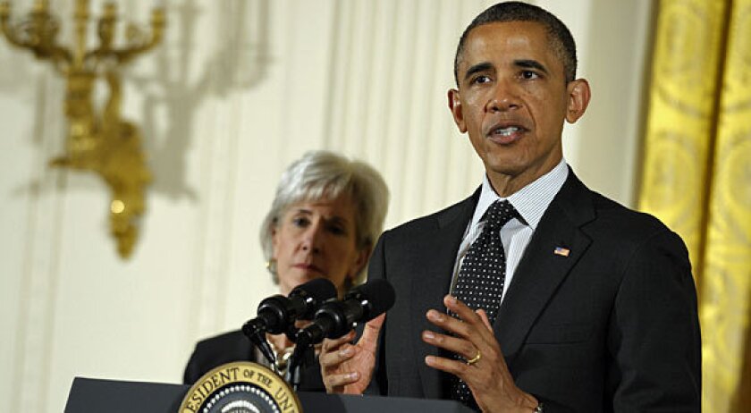President Barack Obama, standing next to Health and Human Services Secretary Kathleen Sebelius.