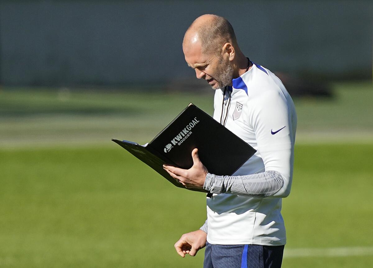 U.S. coach Gregg Berhalter reads some information during a training session.