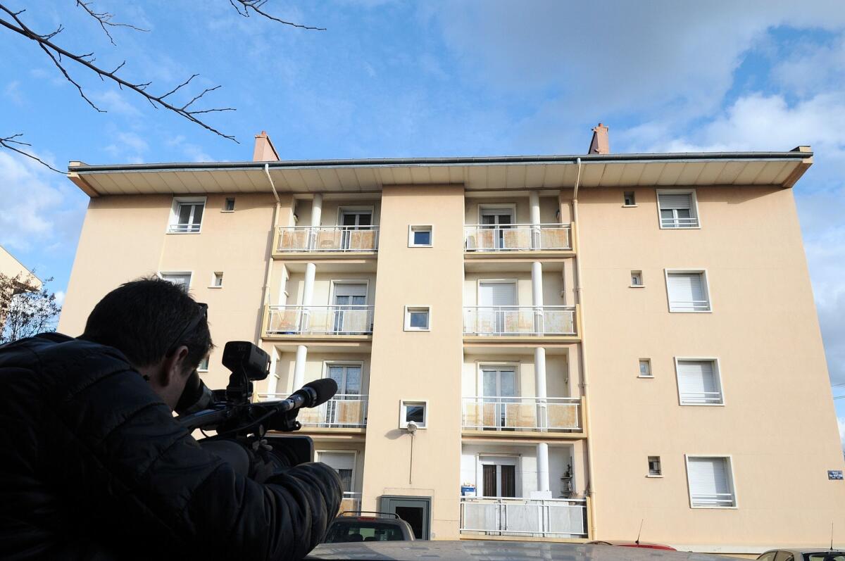 A man on Tuesday films a building in the French city of Beziers, the home of one of five suspects described as Chechens who were arrested after explosive material was found.