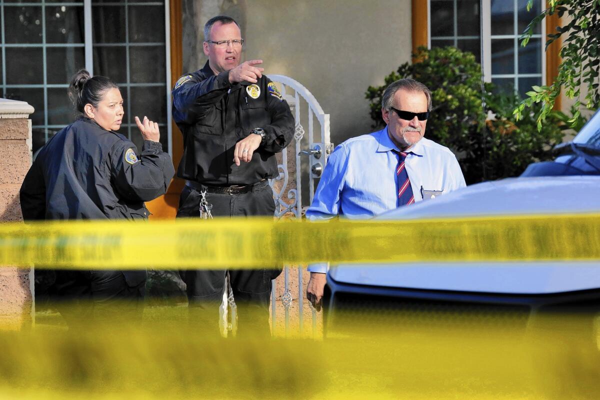 Pomona police investigate at the house where four people were found dead late Thursday.