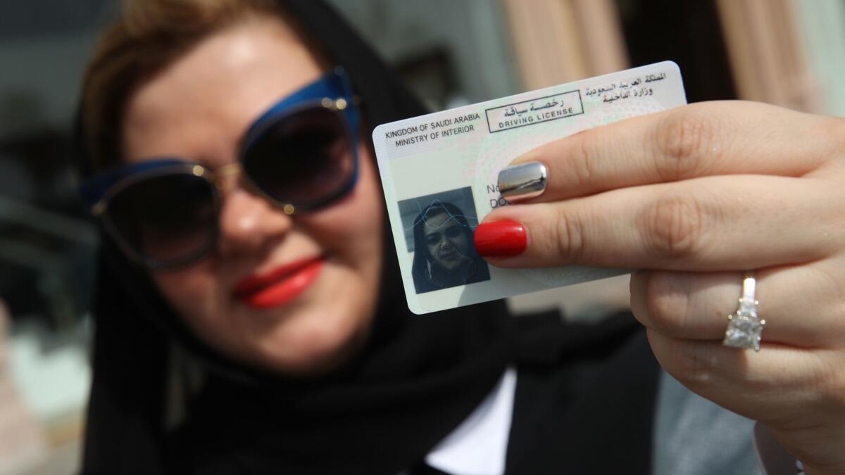 Nada Edlibi holds up her Saudi Arabian driver's license on the first day the ban on female drivers was lifted.