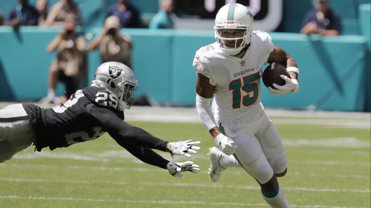 Dolphins receiver Albert Wilson eludes Raiders defensive back Leon Hall during the first half Sunday.