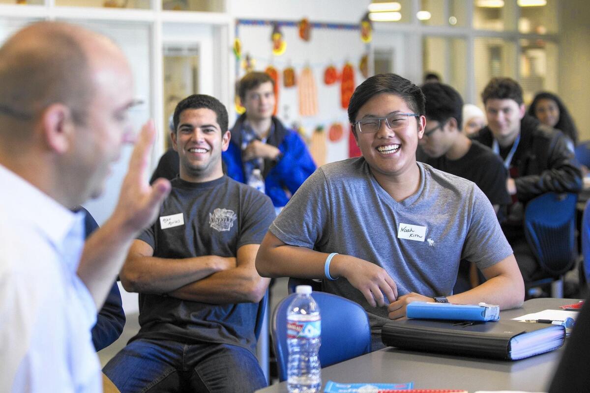 Noah Kim, 17, a culinary arts student at Northwood High School, laughs at a joke from Rusty Bills, the senior director of operations for Wienerschnitzel, during the Force in Training Day on Oct. 25.