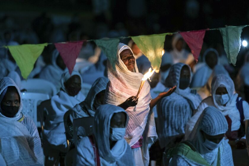 Ethiopian Orthodox Christians light candles and pray for peace during a church service at the Medhane Alem Cathedral in the Bole Medhanealem area of the capital Addis Ababa, Ethiopia Thursday, Nov. 5, 2020. Ethiopia's powerful Tigray region asserts that fighter jets have bombed locations around its capital, Mekele, aiming to force the region "into submission," while Ethiopia's army says it has been forced into an "unexpected and aimless war." (AP Photo/Mulugeta Ayene)