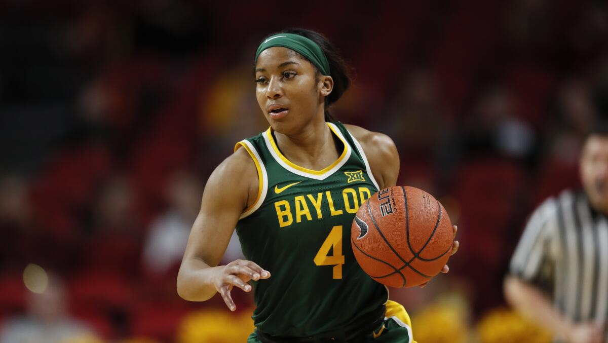 Baylor guard Te'a Cooper drives upcourt in an NCAA college basketball game against Iowa State.