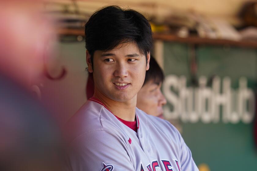 Los Angeles Angels' Shohei Ohtani stands in the dugout during the seventh inning.