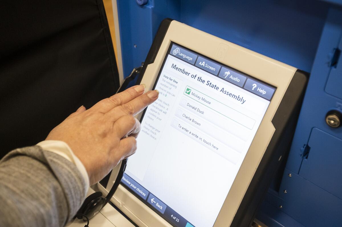 Catherine Miller casts a mock vote on a voting machine during a presentation at the Costa Mesa Senior Center about changes to California's voting systems.