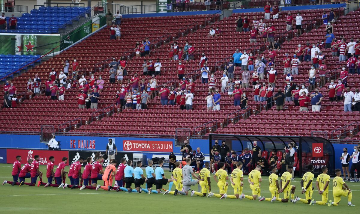 FC Dallas (left) and Nashville SC players kneel during the national anthem before an MLS soccer game at Toyota Stadium on Wednesday, Aug. 12, 2020, in Frisco, Texas. (Smiley N. Pool/The Dallas Morning News via AP)