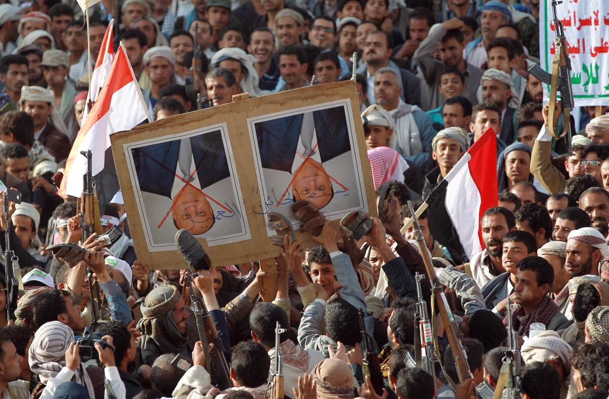 Supporters of the Houthi insurgents use shoes to deface a portrait of Yemeni President Abdu Rabu Mansour Hadi in the capital, Sana.