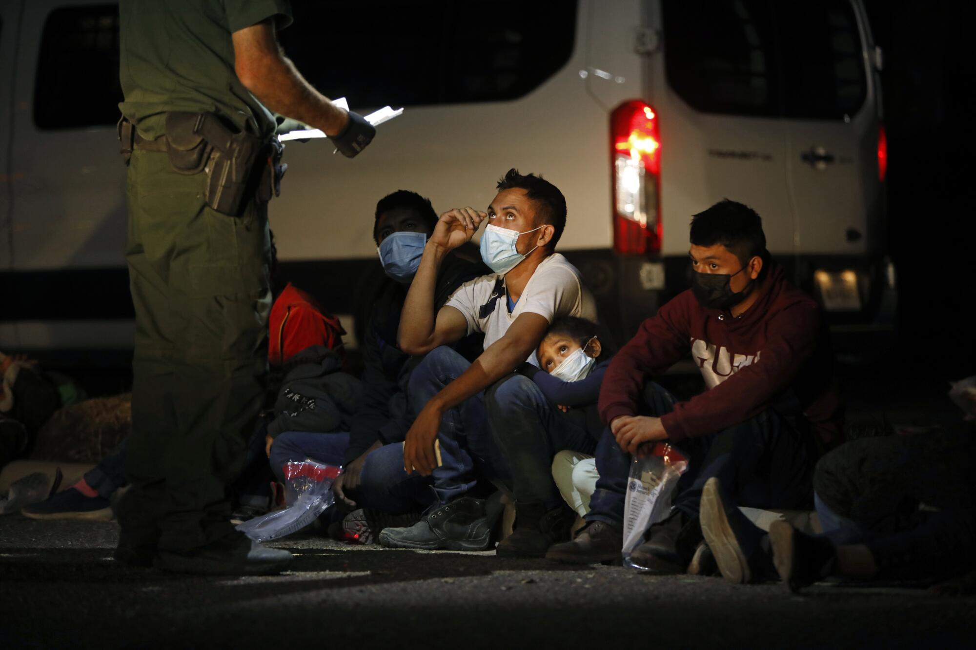 A Border Patrol agent talks to a group of people.