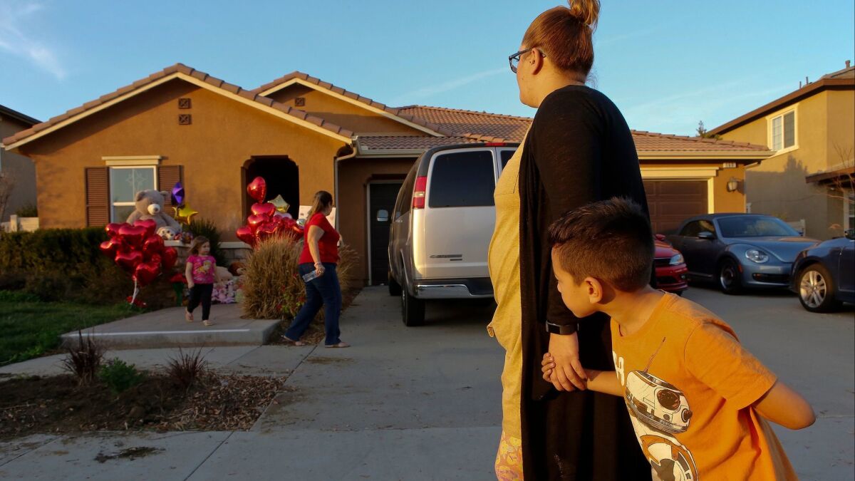 Neighbors look at the home where police arrested a couple accused of holding 13 children captive in Perris, Calif. on Jan. 18, 2018.