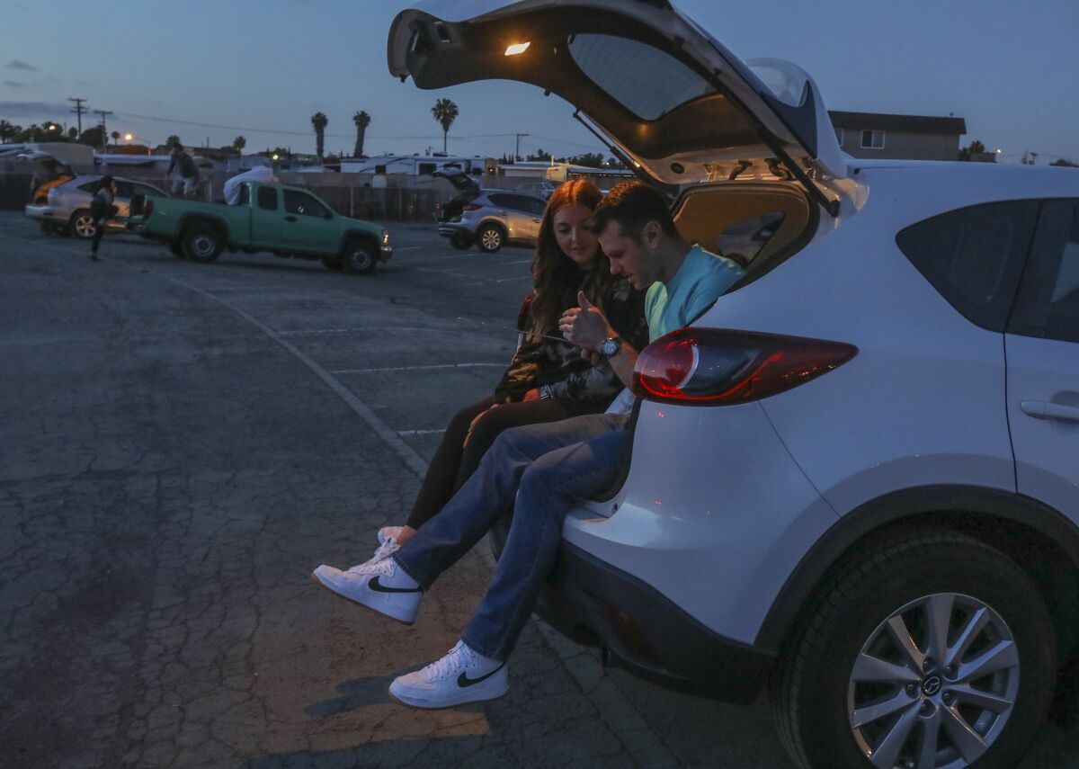 Cara Drayne, left, and Matt Howarth wait to watch the movie "Knives Out" at the South Bay Drive-In Theaters, which reopened last weekend.