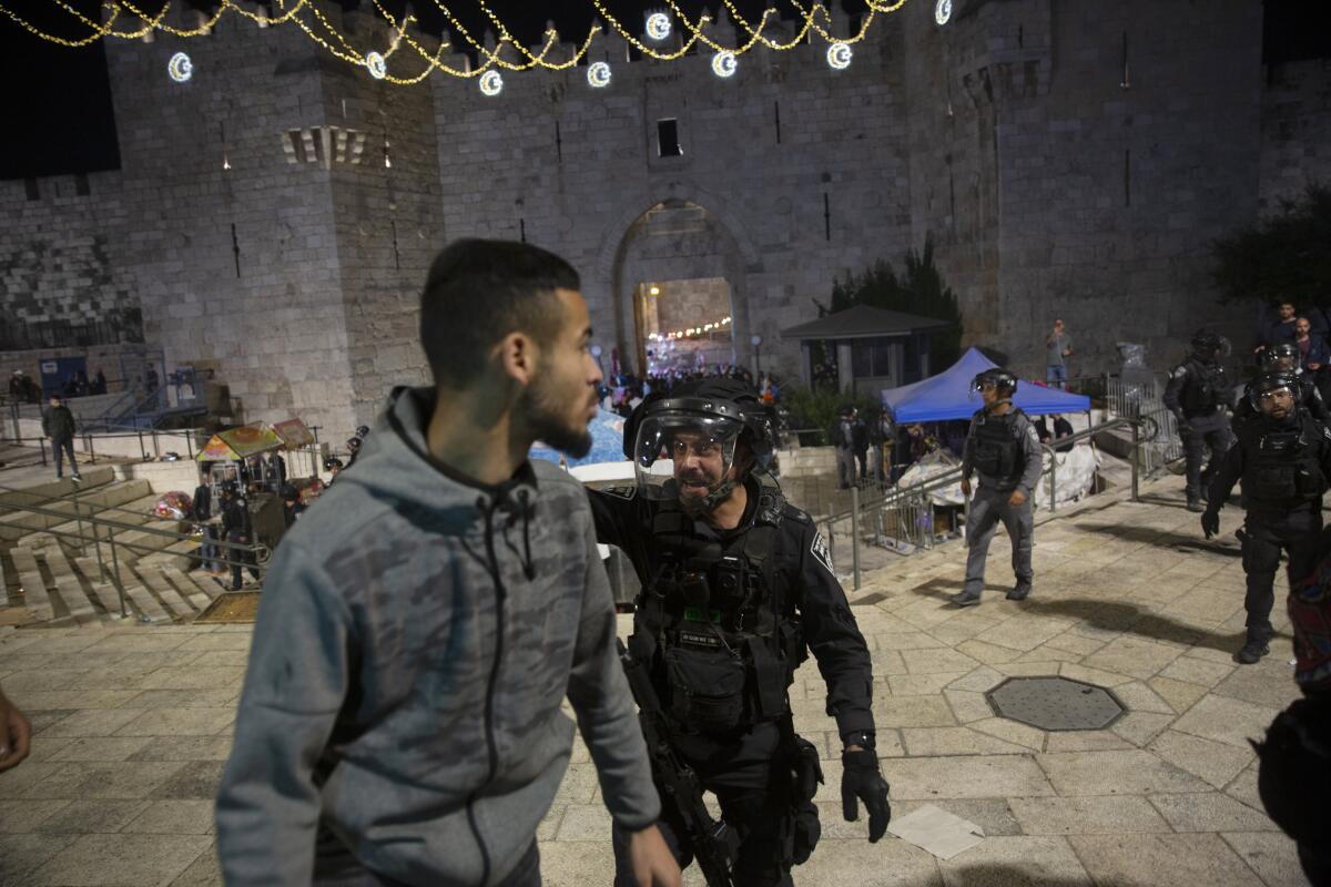 An Israeli police officer shouts at a Palestinian man.