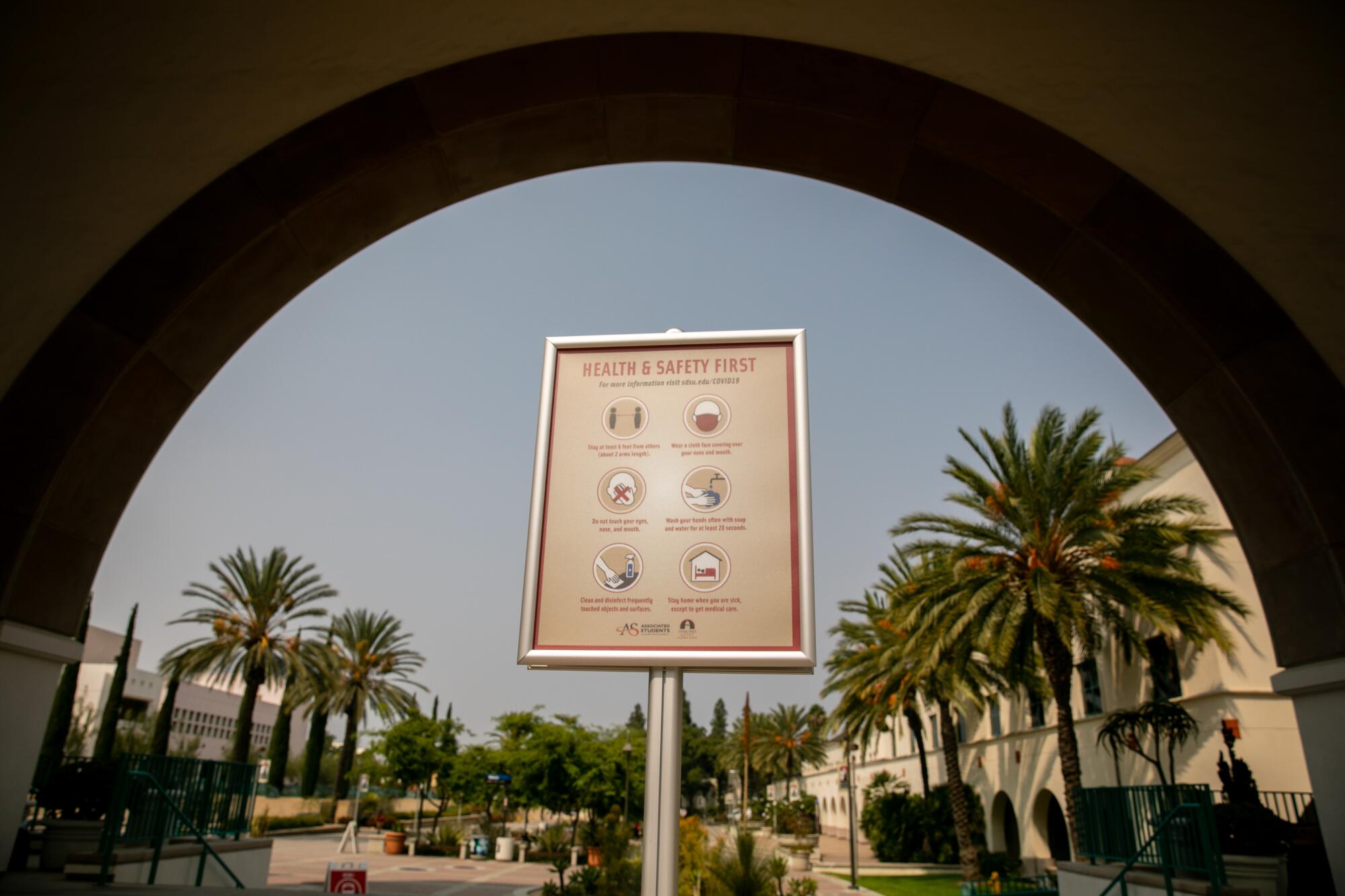 Signs provide warnings and information about COVID-19 on the campus of San Diego State University 